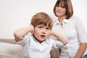 Mom looking at child putting hands over his ears