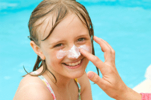 parent applying sunscreen to child